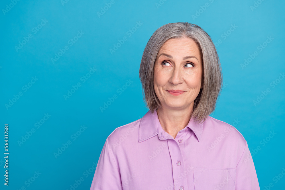 Photo of adorable intelligent lady wear violet stylish clothes interested look empty space banner isolated on blue color background Photo of adorable intelligent lady wear violet stylish clothes interested look empty space banner isolated on blue color background