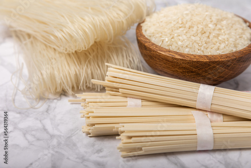Rice noodles.Rice and noodles with rice flour in a wooden plate on a white marble background.Close-up.Useful and healthy food. Place for text. Copy space.