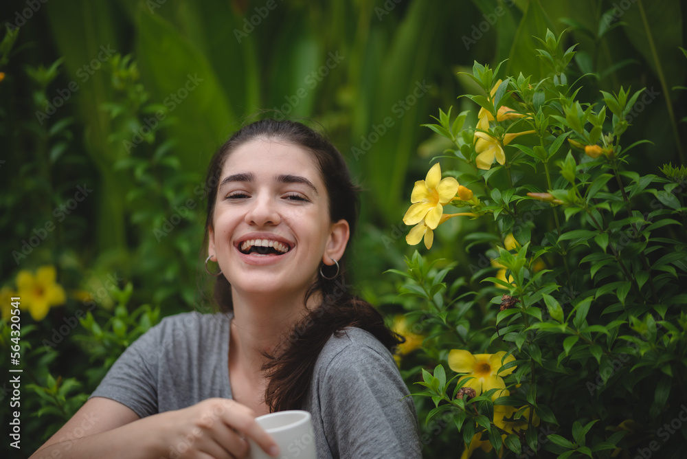 Relaxed young female smiling and looking side, sitting on home terrace. Hobby and resting leisure concept, Gardener girl relaxing after taking care of a plants in home garden. relaxation wellness Relaxed young female smiling and looking side, sitting on home terrace. Hobby and resting leisure concept, Gardener girl relaxing after taking care of a plants in home garden. relaxation wellness