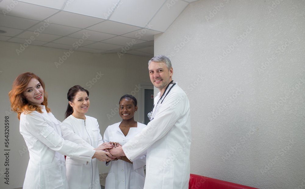 clinic, profession, people, healthcare and the concept of medicine - a happy group of doctors or doctors in a hospital corridor. clinic, profession, people, healthcare and the concept of medicine - a happy group of doctors or doctors in a hospital corridor.