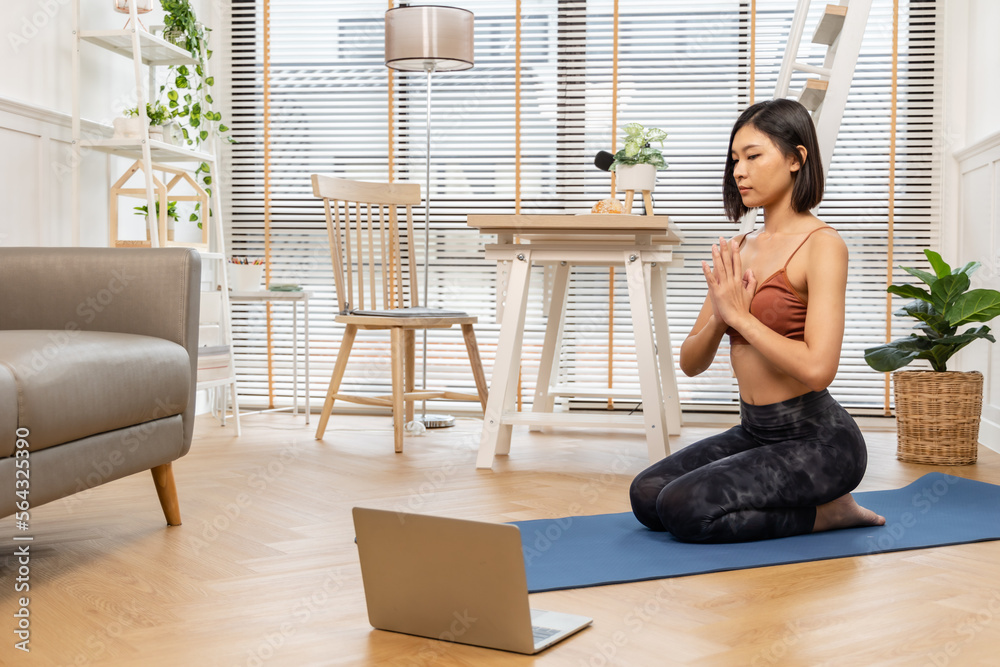 Young Asian woman doing yoga stretching yoga at home.Happy people stay home, doing aerobic exercise at living room Girl doing lockdown activity, workout with trainer for health in house. Young Asian woman doing yoga stretching yoga at home.Happy people stay home, doing aerobic exercise at living room Girl doing lockdown activity, workout with trainer for health in house.
