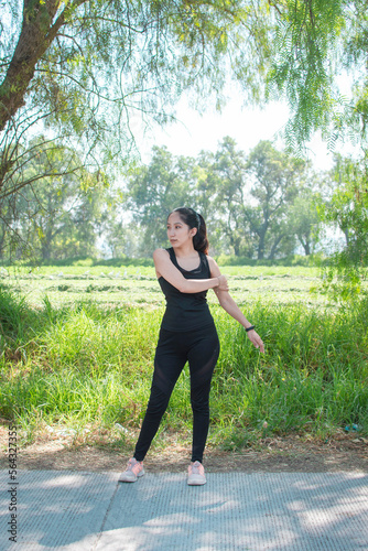 Mujer joven delgada caucasica en la naturaleza estirandose y calentando para correr o practicar ejercicio vida saludable  photo