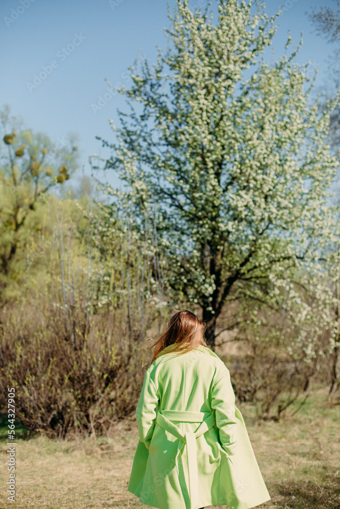 stylish woman green coat background spring flowering