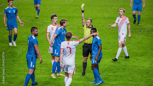 Soccer Football Championship Match: Referee Sees Foul, Gives Signal and Yellow Card, Players Circle him Upset. International Tournament. Sports Broadcast Channel Television Concept.