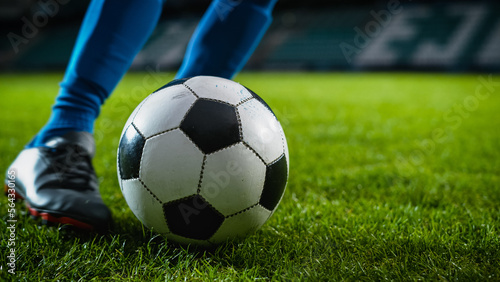 Close-up of a Leg in a Boot Kicking Football Ball. Professional Soccer Player Hits Ball with Fierce Power  Scores Goal  Grass Flying. Beautiful Cinematic Low Angle Ground Artistic Shot