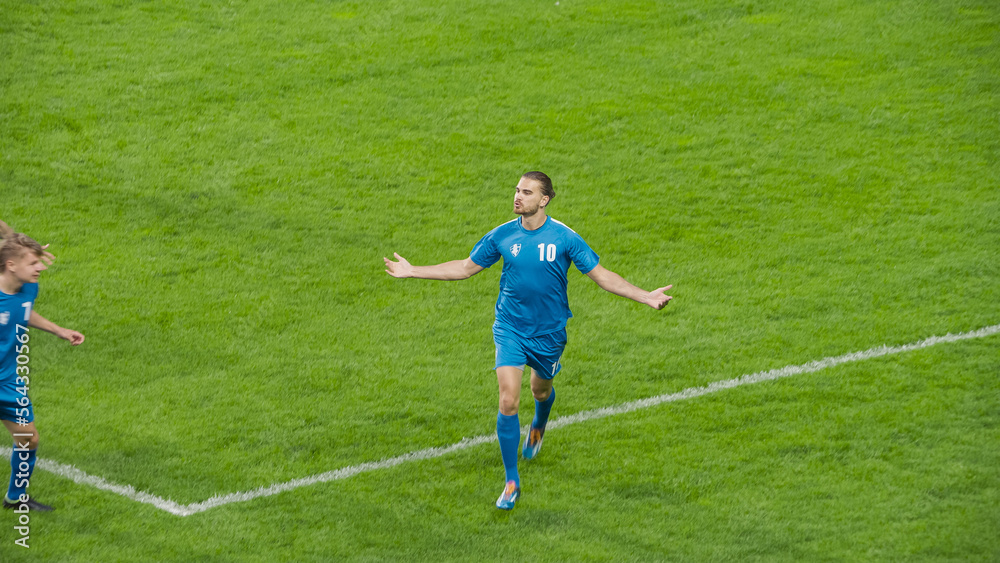 Obraz premium Soccer Football Championship: Blue Team Forward Running Excited After Scoring a Goal in Finals. Team Celebrates. Winners of the Tournament, Crowd of Fans Cheer. Sport TV Broadcast Concept. High Angle.