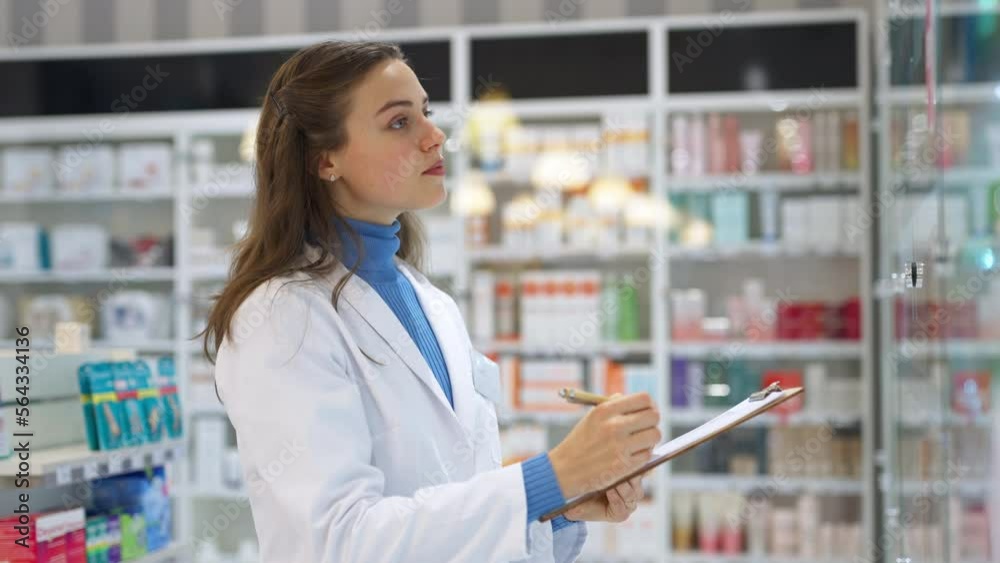 Young pharmacist checking medicine stock in pharmacy. Young pharmacist checking medicine stock in pharmacy.