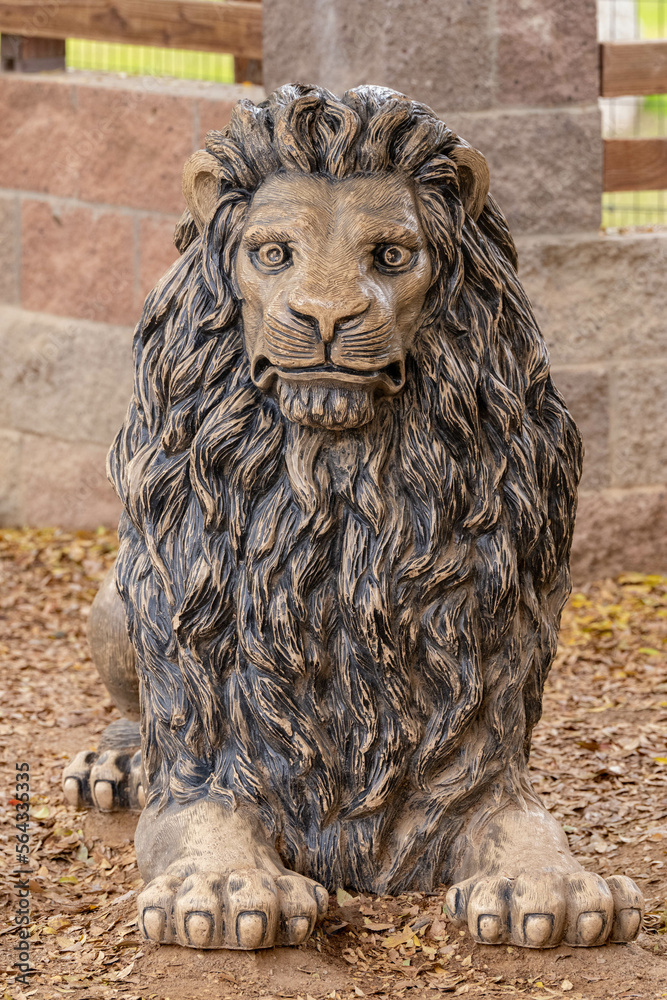 golden statue of a male lion is looking at the camera