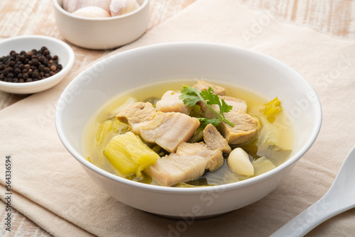 Preserved mustard green with pork belly soup in white bowl