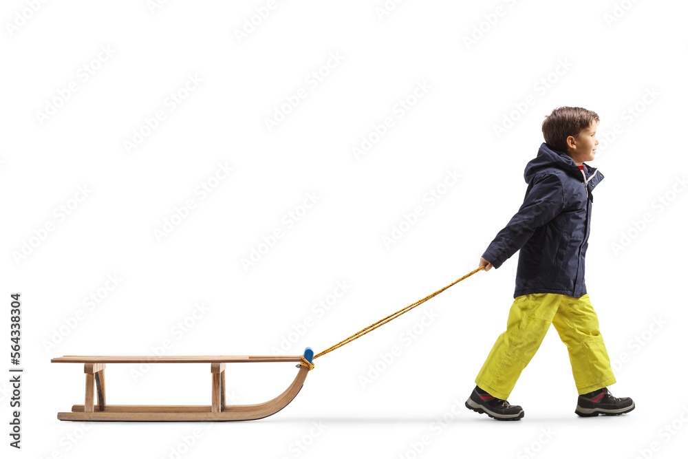 Obraz premium Full length profile shot of a boy pulling a wooden sleigh