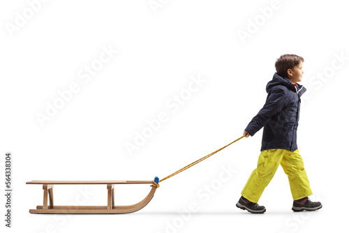 Full length profile shot of a boy pulling a wooden sleigh
