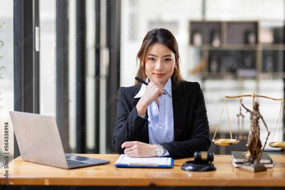 justice and law concept. Lawyer office. Statue of Justice with scales and lawyer Asian Woman working on a laptop. Legal law, advice and justice concept.