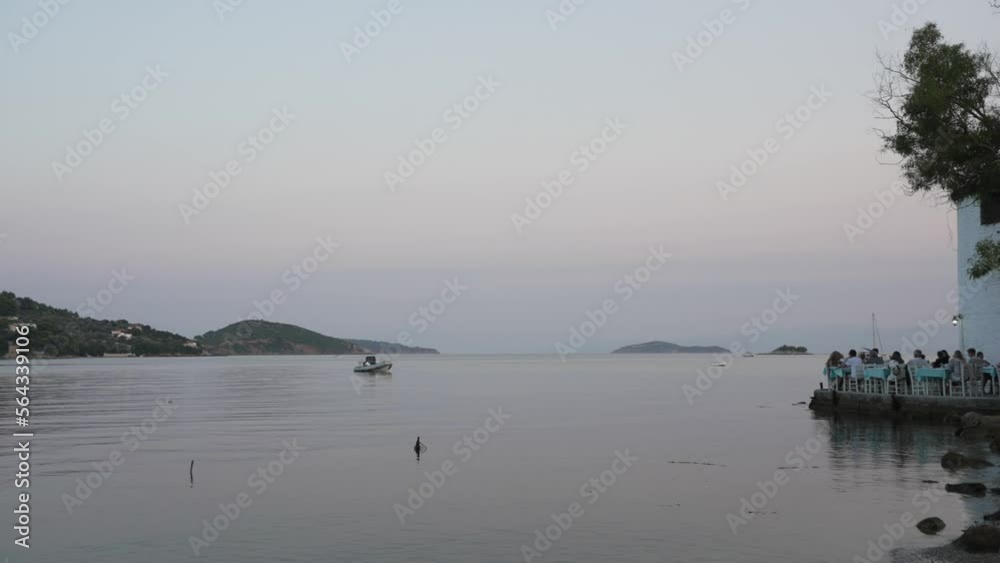 Aegean Sea and restaurant at the edge of town at dusk, Skiathos Town, Skiathos, Sporades Islands, Greek Islands