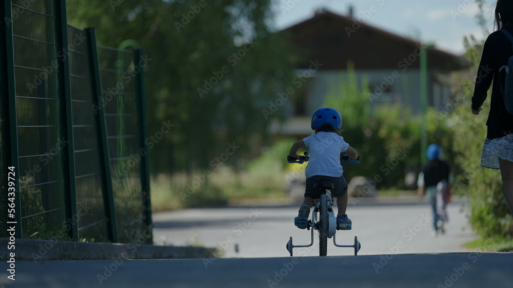 Small boy riding bicycle outside child rides bike wearing helmet