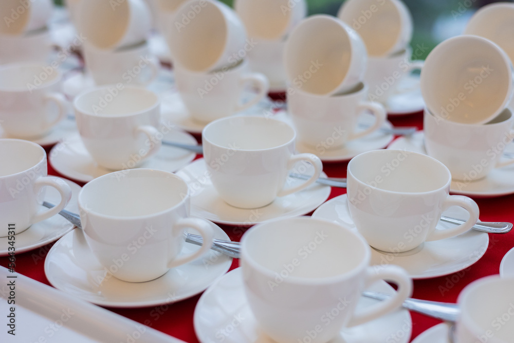 set of white tea cups on red tablecloth set of white tea cups on red tablecloth