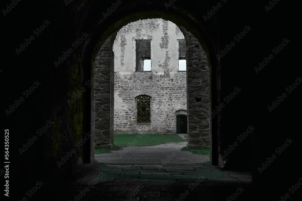 Exit from inside a castle. Arched opening with ancient walls. Military fort, medieval castle. Internal garden and ancient architecture. Exit from inside a castle. Arched opening with ancient walls. Military fort, medieval castle. Internal garden and ancient architecture.