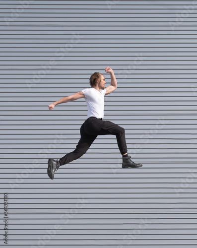 blond caucasian boy jumping doing parkour white t-shirt