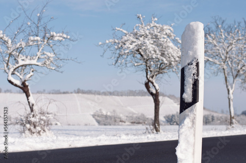 snow-covered country road bollard