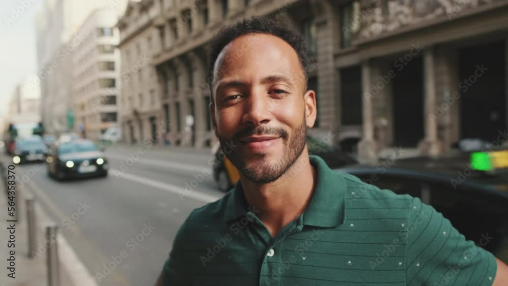 Close-up of happy young man standing on the street. Guy turns his head and smiles at the camera Close-up of happy young man standing on the street. Guy turns his head and smiles at the camera