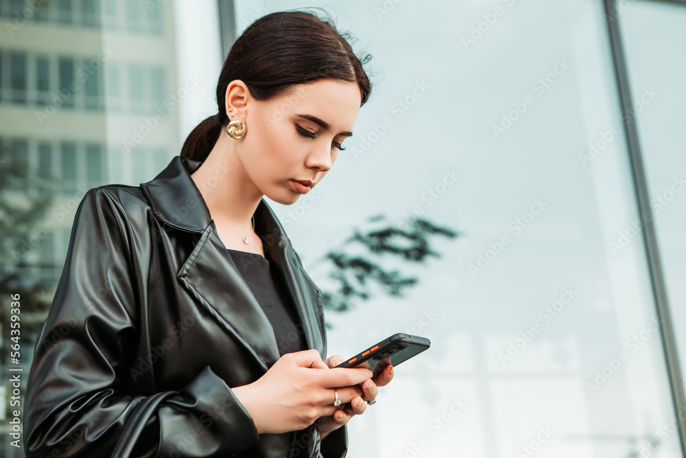Pretty brunette caucasian woman dressed leather suit with shoulder bag walking outside hold mobile phone, order taxi, ride sharing, typing message texting chatting, search information on the Internet
Pretty brunette caucasian woman dressed leather suit with shoulder bag walking outside hold mobile phone, order taxi, ride sharing, typing message texting chatting, search information on the Internet