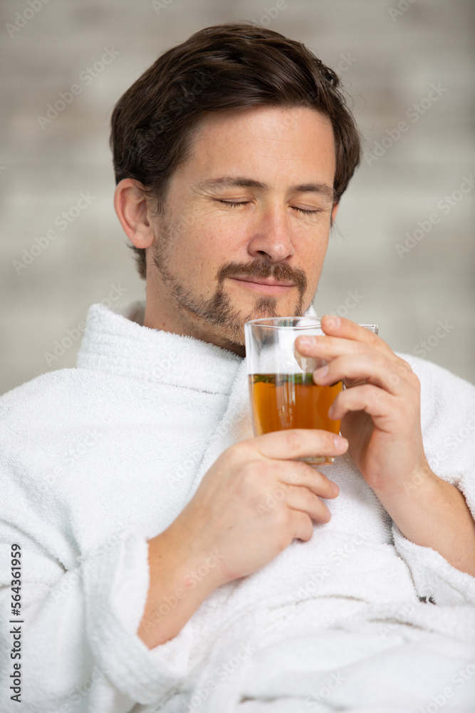 handsome man having breakfast in his bathrobe smiling handsome man having breakfast in his bathrobe smiling