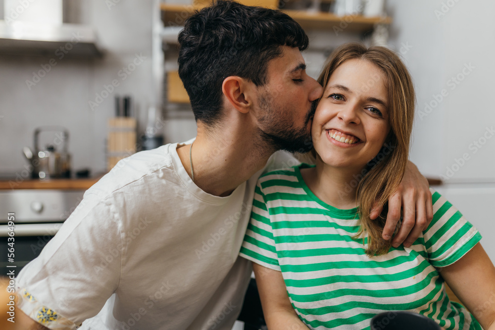 Man is kissing his girlfriend on the cheek Man is kissing his girlfriend on the cheek