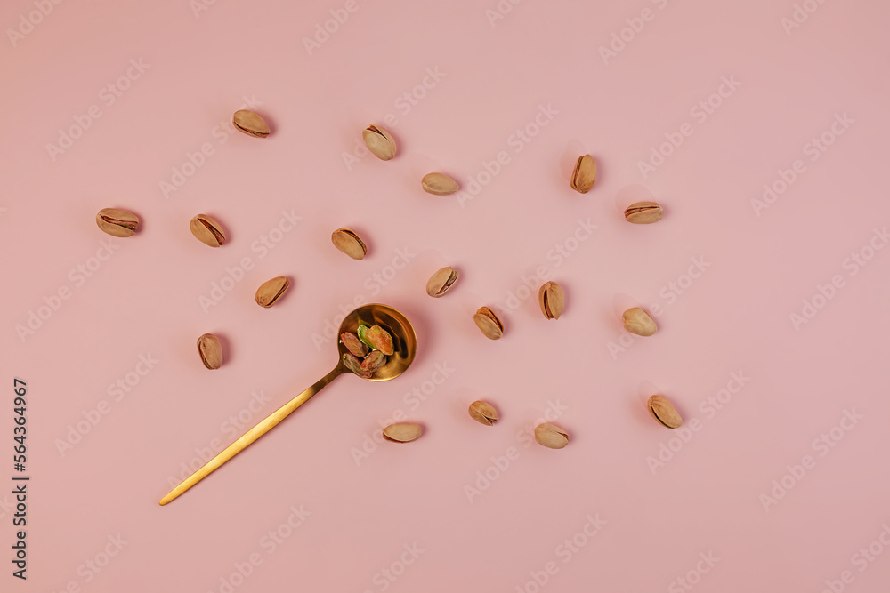 Pistachios in the spoon on the pink background, healthy nuts Pistachios in the spoon on the pink background, healthy nuts