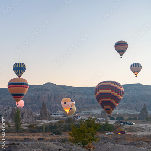 Colorful hot air balloons fly over the fabulous rocks in Cappadocia, Turkey.