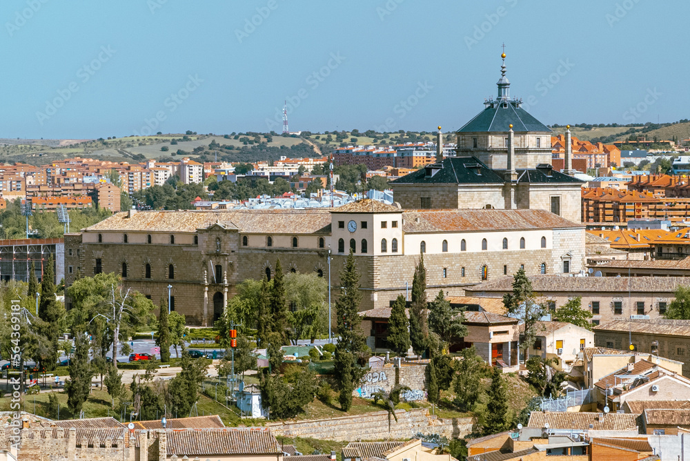 Toledo, España. April 29, 2022: Tavera Hospital and panoramic landscape with blue sky. - obrazy, fototapety, plakaty 