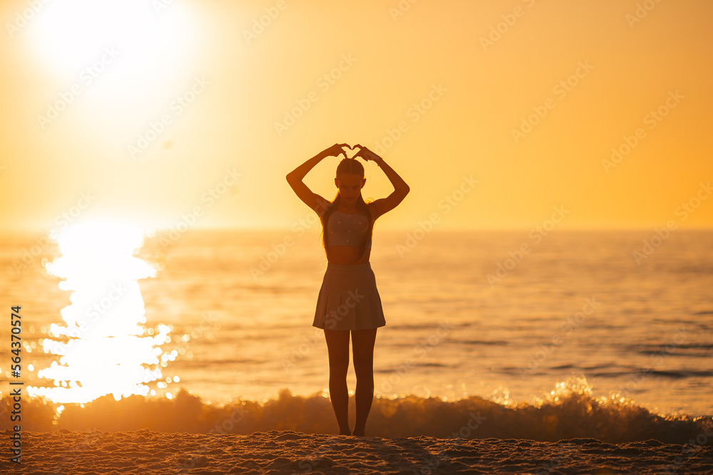 Happy teen girl enjoy tropical beach vacation at sunset