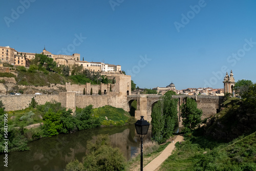 Toledo, España. April 29, 2022:Alcantara Roman Bridge with landscape and blue sky.