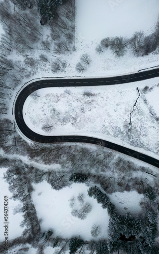 top down view of hairpin corner going through the snow covert winter mountains