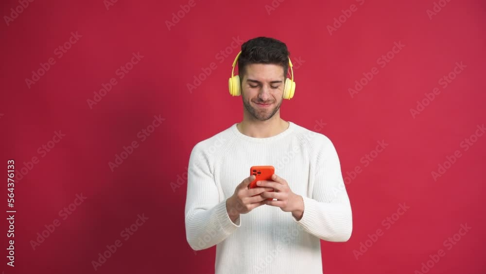 Cheerful young man in headphones using smartphone Cheerful young man in headphones using smartphone