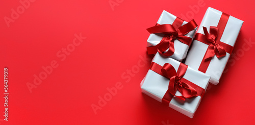 Gift boxes for Valentine's Day on red background with space for text, top view