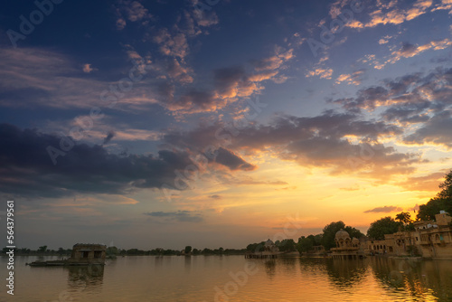 Nice sunset at Gadisar lake, Jaisalmer, Rajasthan, India. Setting sun and colorful clouds in the sky with view of the Gadisar lake. Connected with Indira Gandhi Canal for continuous water supply.