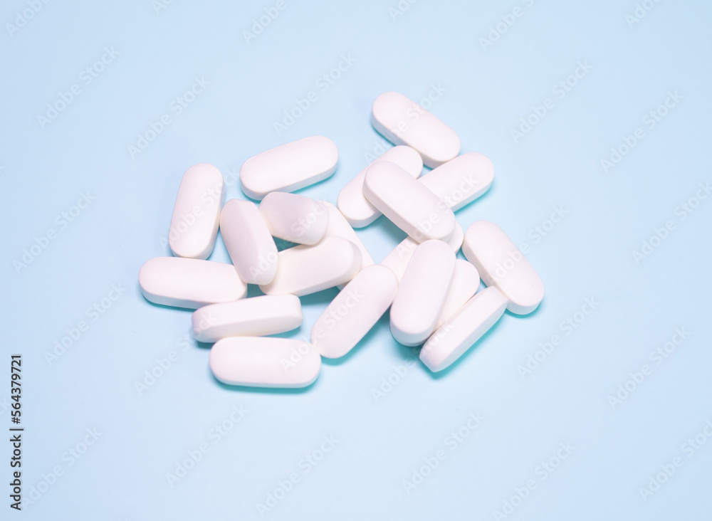 Spilled coloured medications and pills on a blue background. Pharmacology and medicine struggle for health. Spilled coloured medications and pills on a blue background. Pharmacology and medicine struggle for health.
