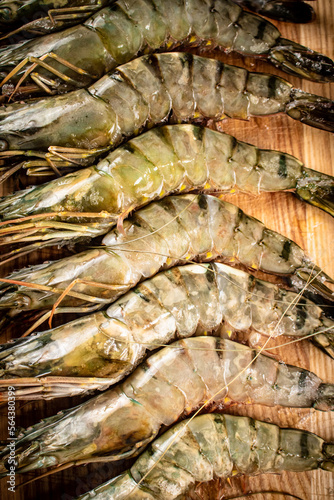 Raw shrimp on a wooden background.