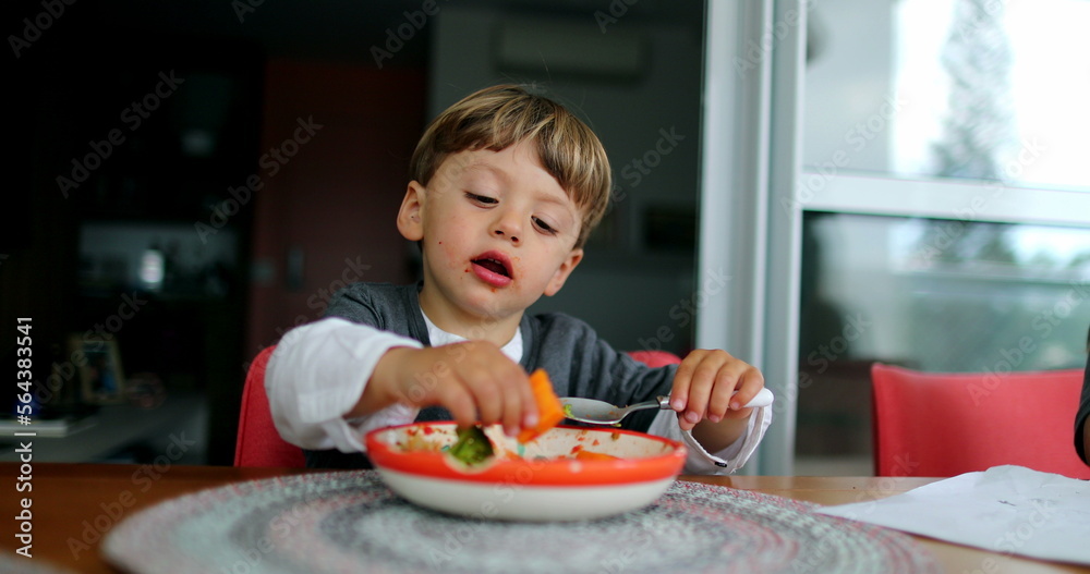 One happy little boy eating food by himself healthy lunch