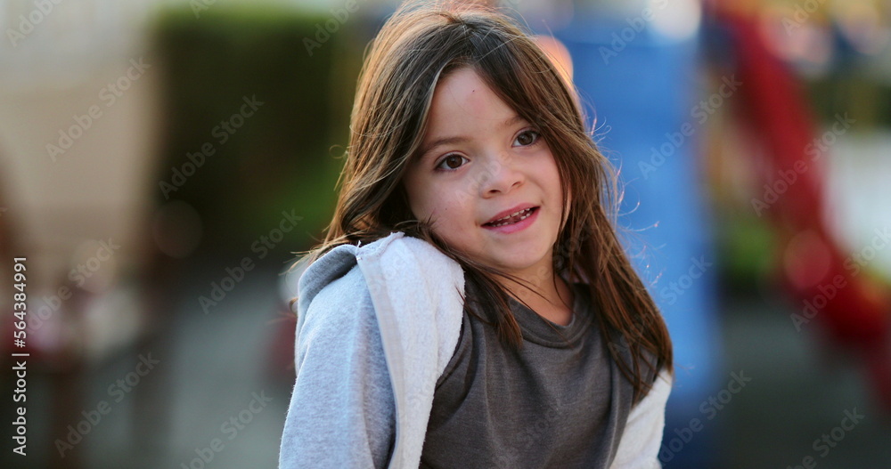 Cute child standing outside in sunlight adorable little girl portrait face closeup