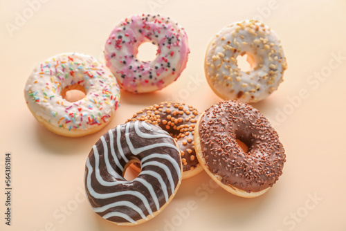 Different glazed donuts on color background