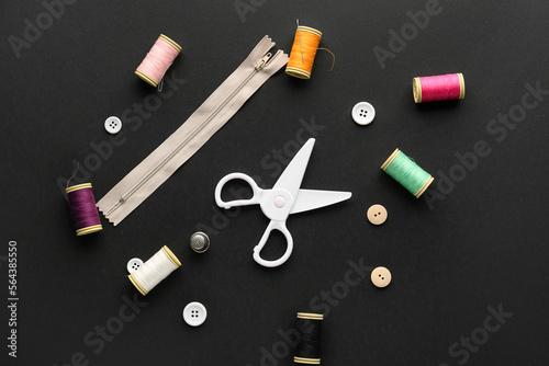 Set of sewing supplies with scissors on dark background
