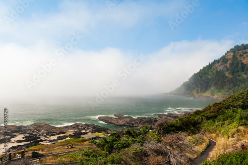 Scenic view of rocky beach near town of  Yatchats, with people on the beach, Oregon, USA photo