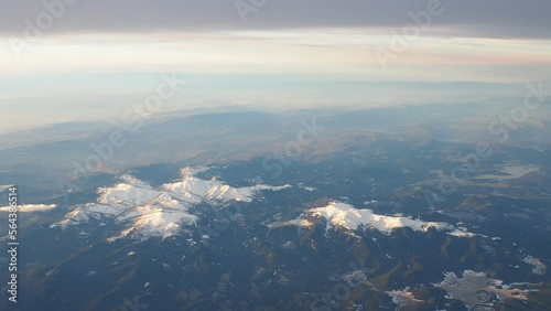 Turkey, Ankara. View from airplane window to the Turkish mountains, lakes and snowy peaks. Layered clouds and horizon. Lakes Saryar, Nallihan and Camlidere. Departure from Esenboga Havalimani Airport photo