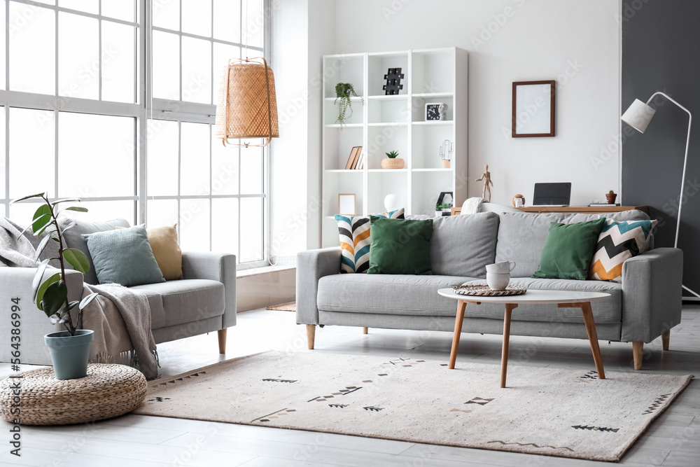 Interior of modern living room with grey sofas, window and shelving unit  Stock Photo | Adobe Stock