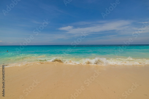 Beautiful view of sandy beach of Atlantic Ocean with incoming wave on shore. Aruba island.