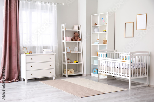 Stylish interior of children's room with baby bed