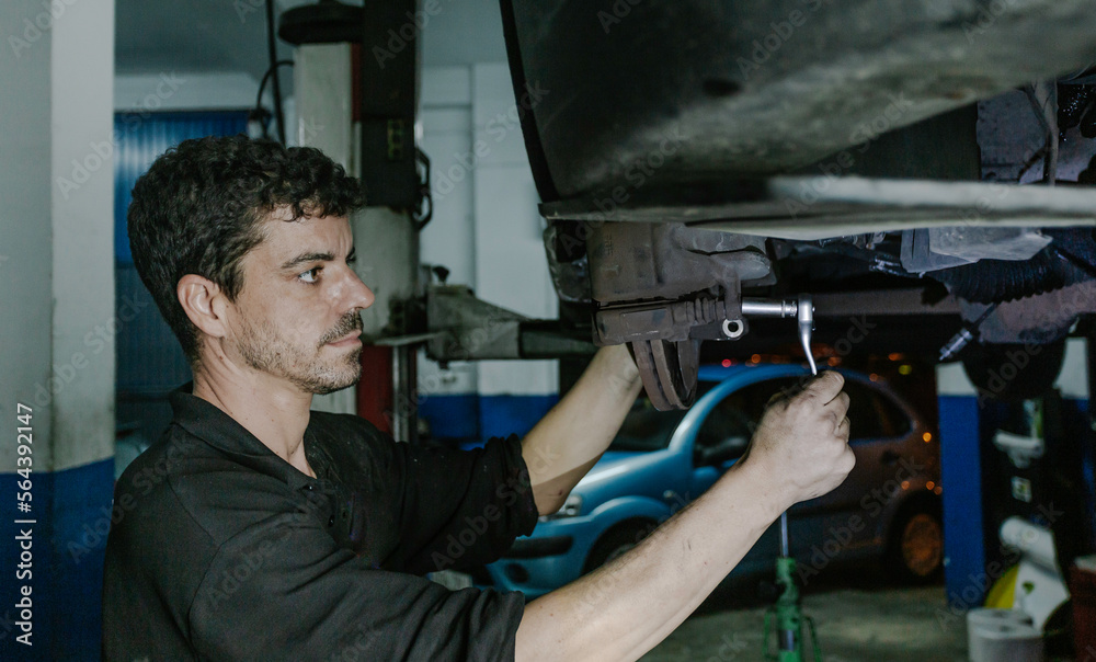 Repairman installing brake discs in workshop Repairman installing brake discs in workshop