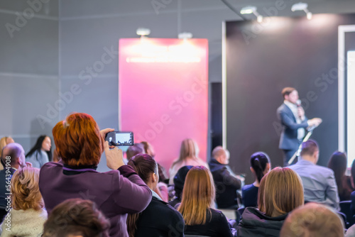 Business, congress, seminar, corporate, training, education concept. Back view of unrecognizable people, audience listening lecture, presentation at trade show, conference hall