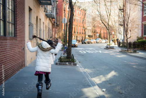 Young asian girl joyfully running the streets in urban city