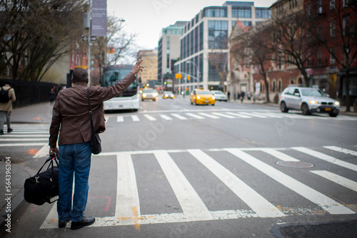 Canvas-taulu Person raising their arm to hail a yellow cab in New York City